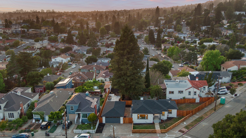 Aerial view of the property highlighting the corner lot, fenced yard, and surrounding neighborhood.
