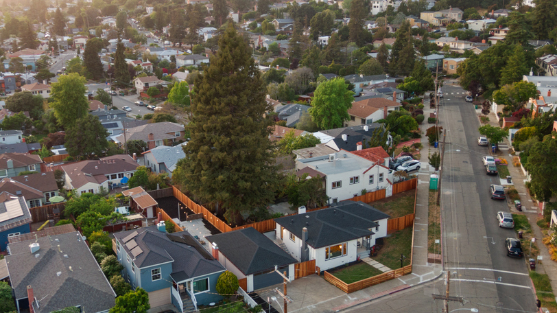 Aerial view showcasing the corner-lot location, fenced yard, and surrounding residential neighborhood.