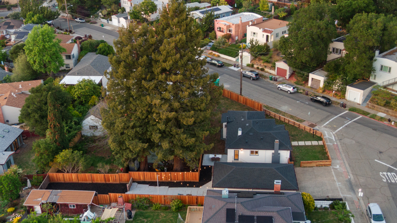 Aerial view highlighting the expansive lot, mature trees, and desirable corner location.