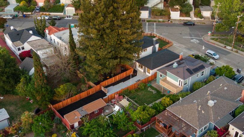Aerial view highlighting the spacious backyard, mature trees, and expansive outdoor living potential.