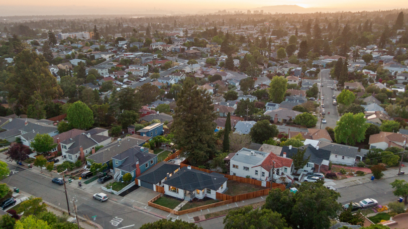 Aerial view showcasing the corner-lot setting, fenced yard, and convenient access to surrounding neighborhoods.