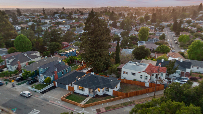 Aerial view highlighting the corner-lot location, expansive yard, and mature trees within a well-established neighborhood.